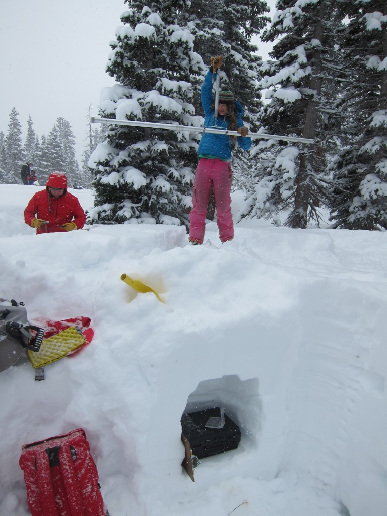 Evaluating snow properties in the mountains after a heavy winter storm.